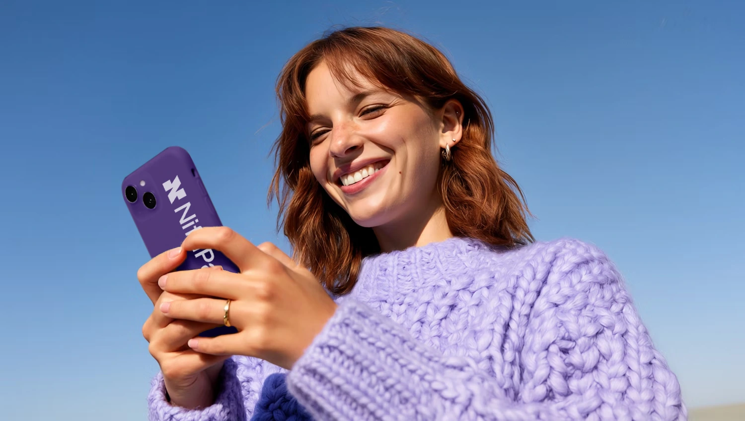 Woman smiling while using the Niftipay app on a phone