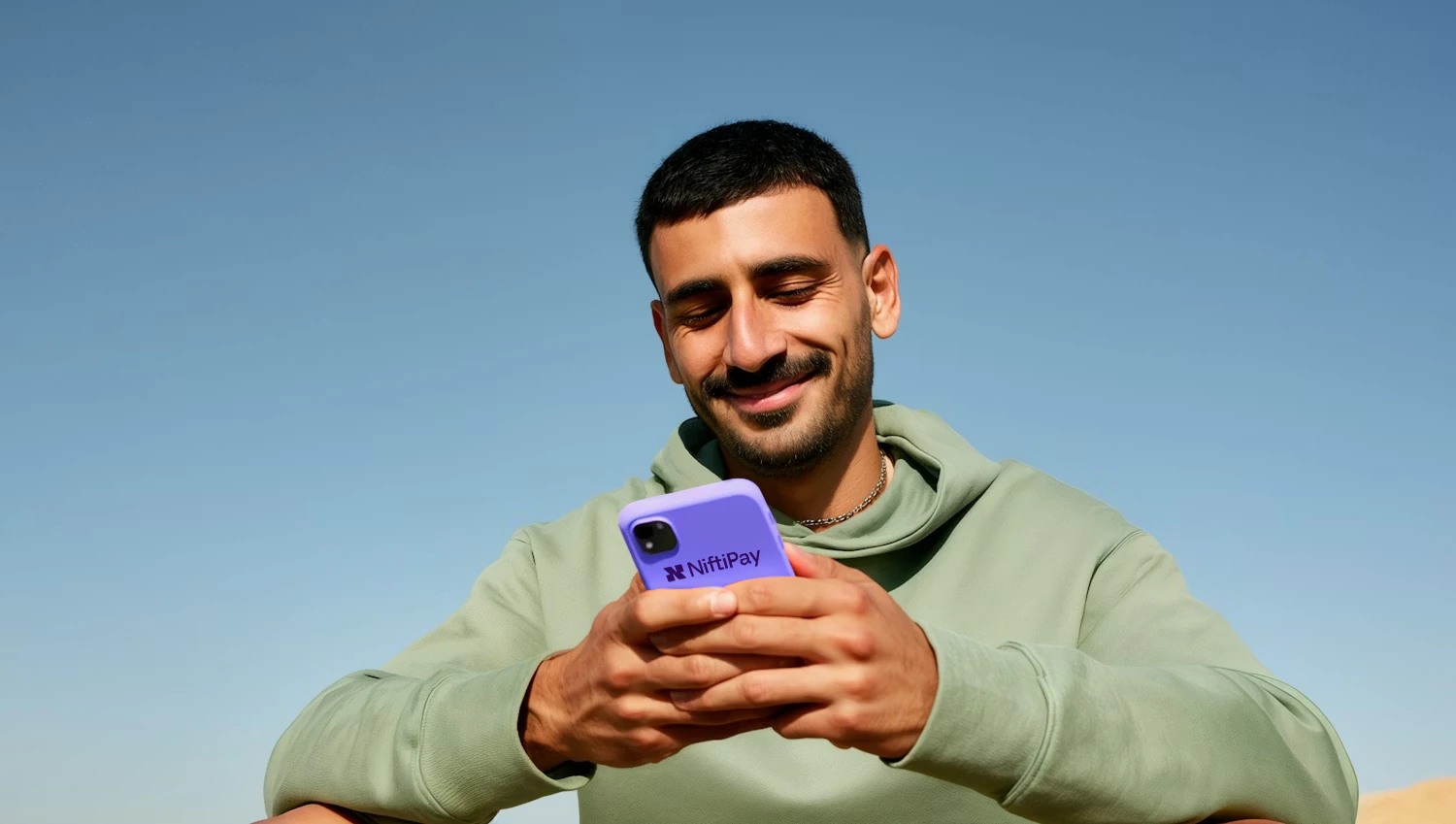 Man holding phone showing Niftipay app